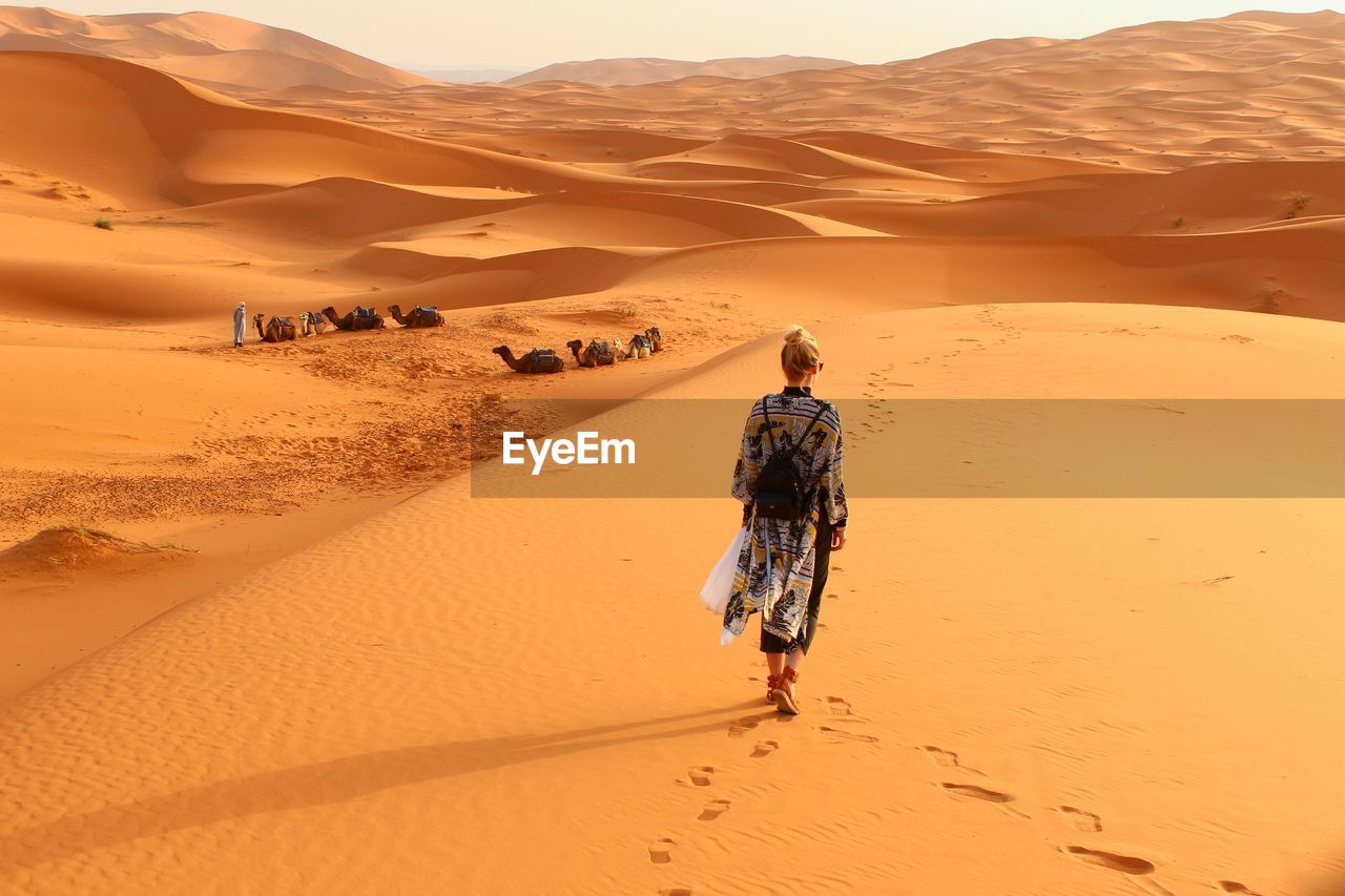 Rear view of woman walking in desert