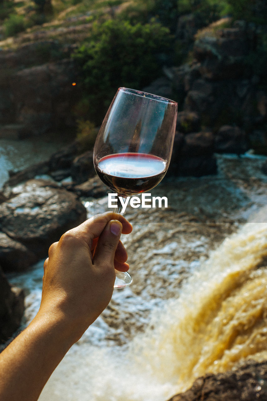 Midsection of the person holding glass wine