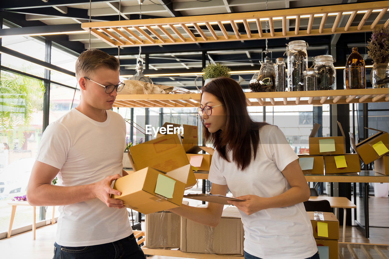 Man giving boxes to woman