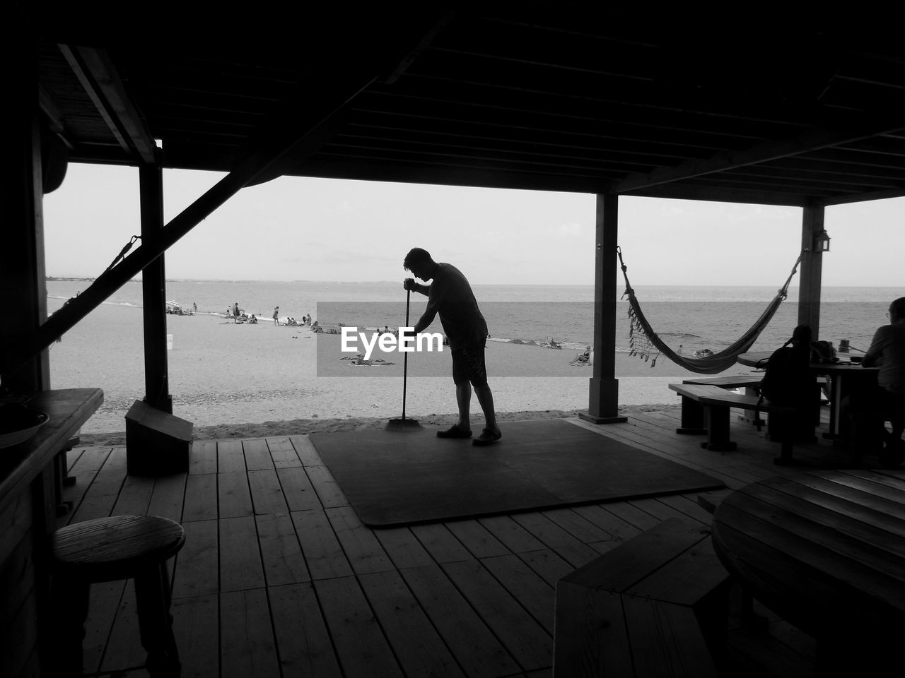 Man cleaning cafe at beach