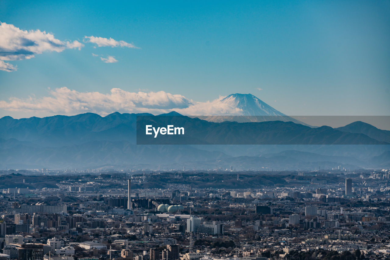 AERIAL VIEW OF CITYSCAPE AGAINST MOUNTAINS
