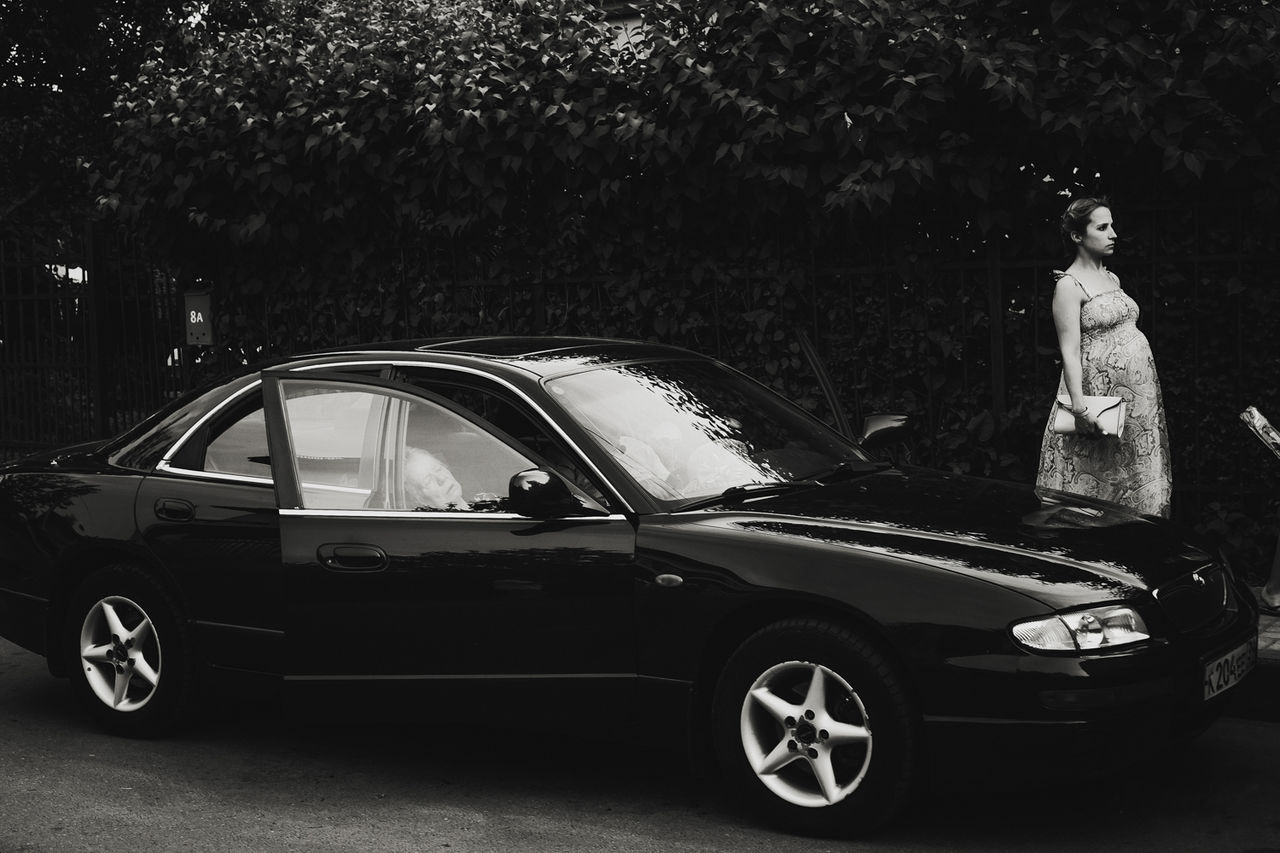 MAN WITH CAR IN BACKGROUND