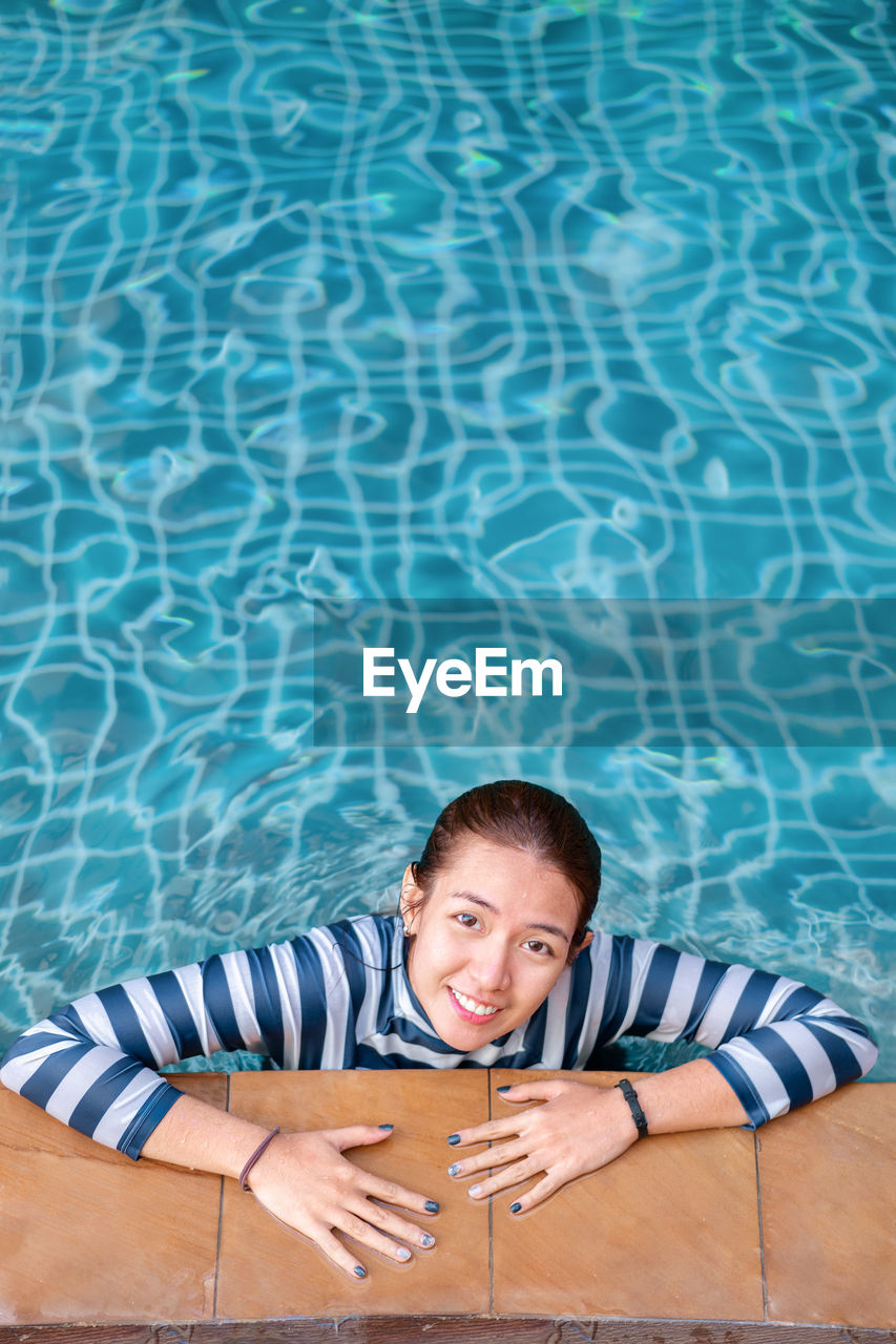 Portrait of smiling woman in l swimming pool