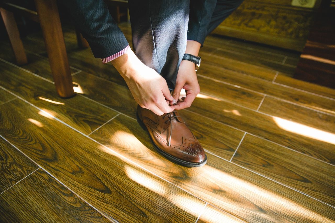 Low section of businessman tying shoe