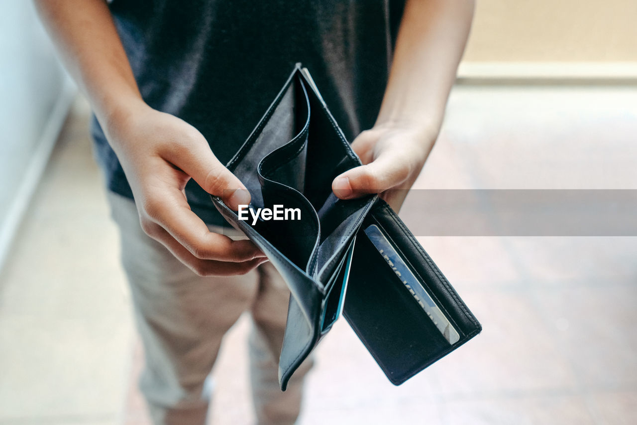 Midsection of man showing empty wallet
