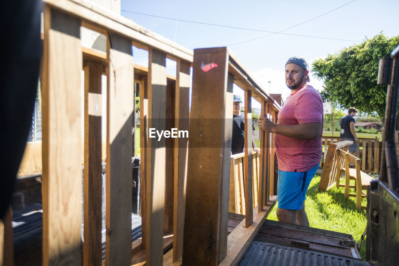 Men lift wood furniture into back of truck on moving day.