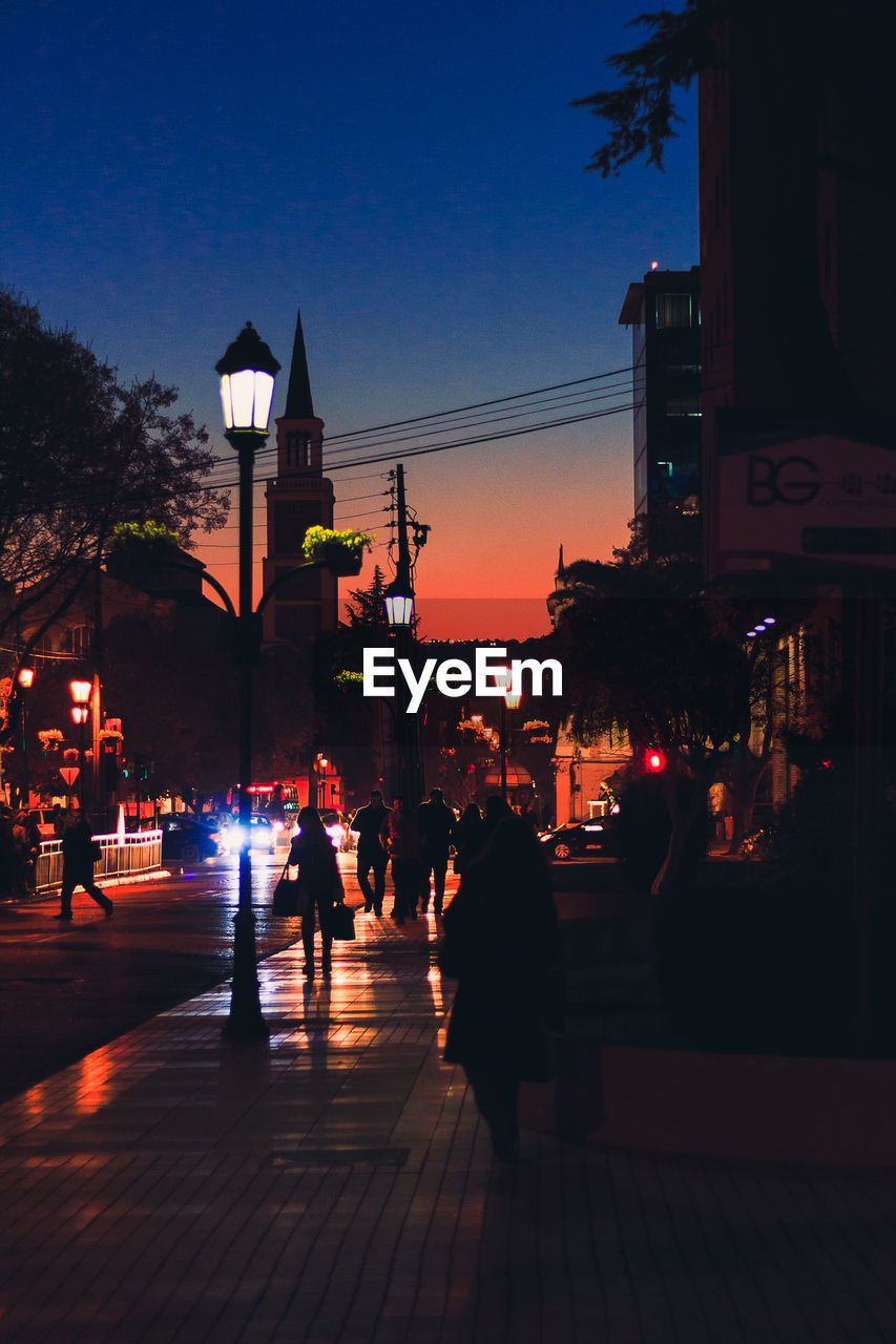 SILHOUETTE PEOPLE AT ILLUMINATED STREET AT NIGHT