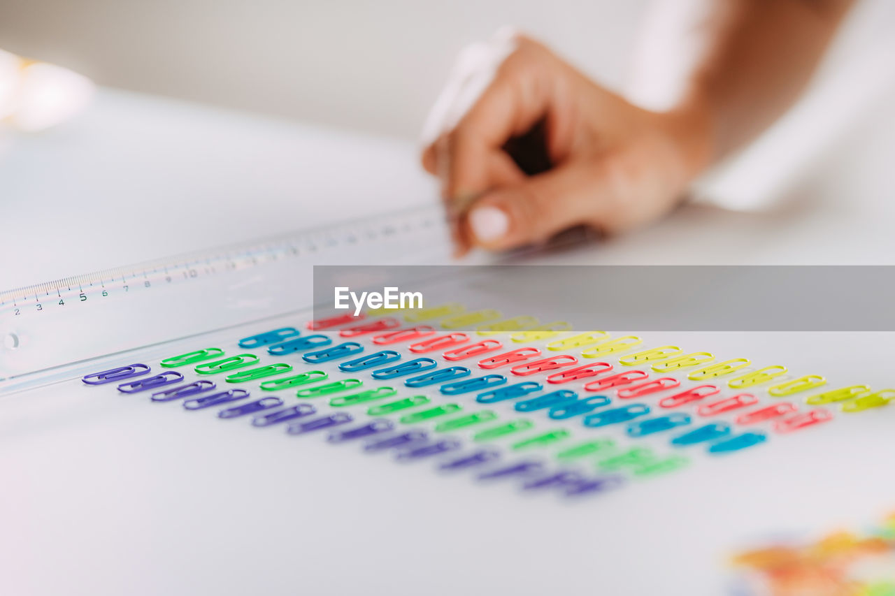 Woman with ocd. obsessive compulsive disorder concept. placing paperclips in a straight line.