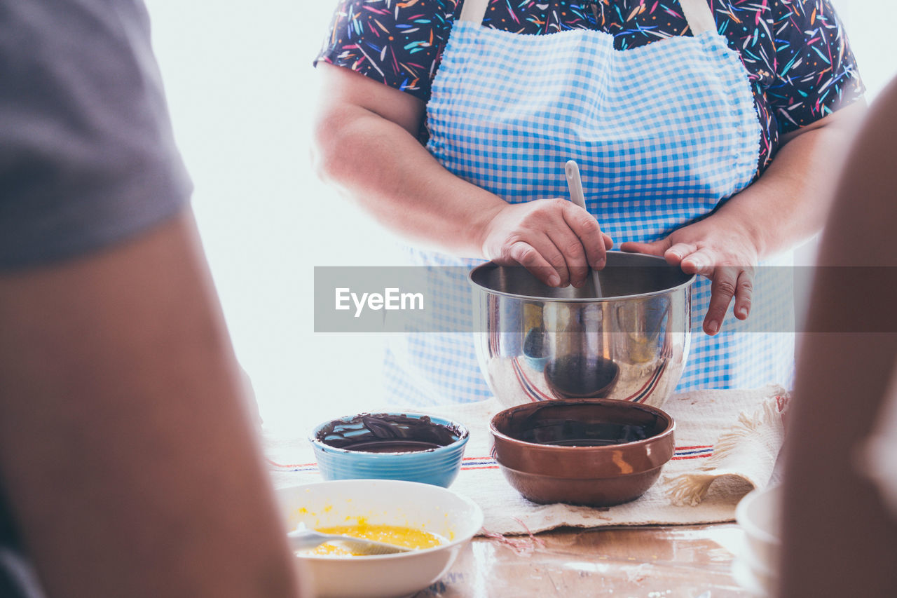 Midsection of women preparing food at table