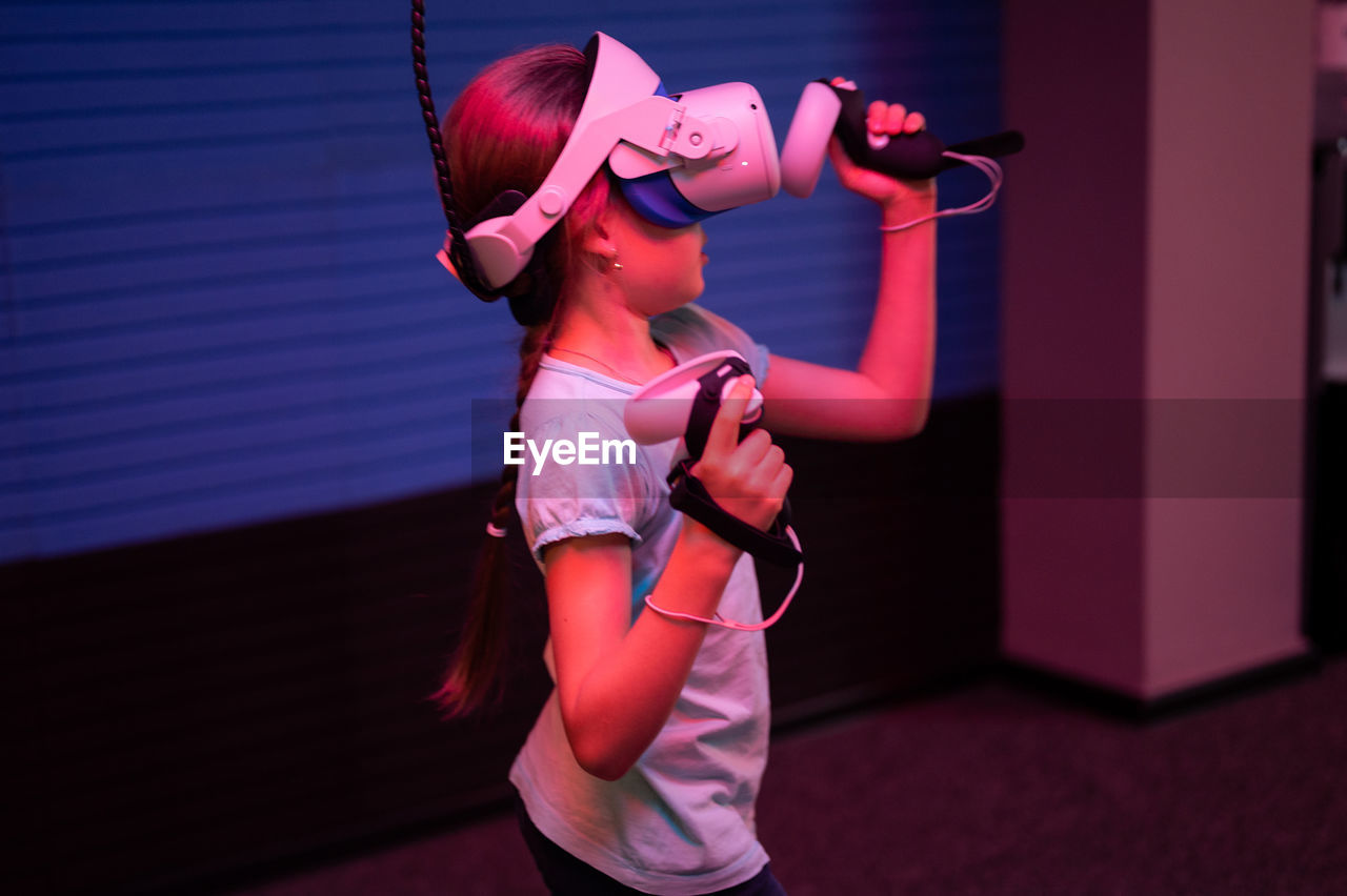 Vr game and virtual reality. kid girl gamer eight years old fun playing on simulation video game