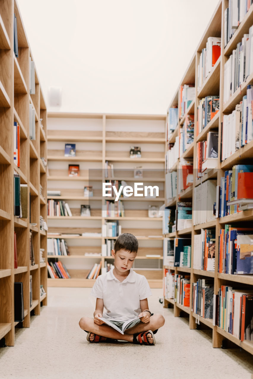 Child in school library. kids read books. little boy reading and studying. children at book store. 