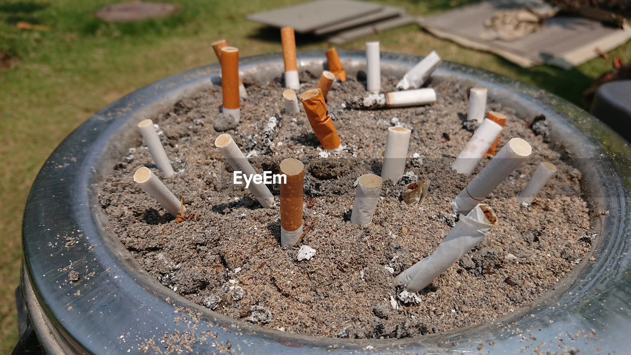CLOSE-UP OF CIGARETTE SMOKING ON TABLE