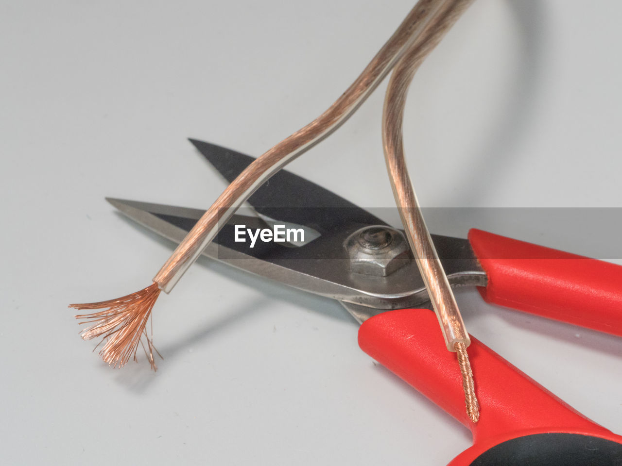 High angle view of electric cables and scissors on gray background