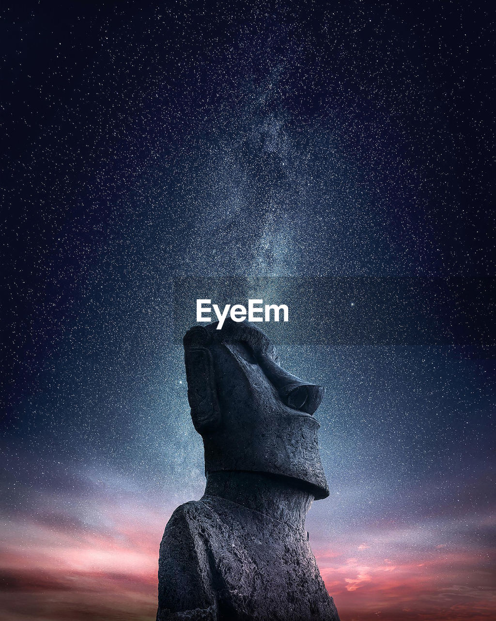 Low angle view of moai statue on mountain against starry sky at night