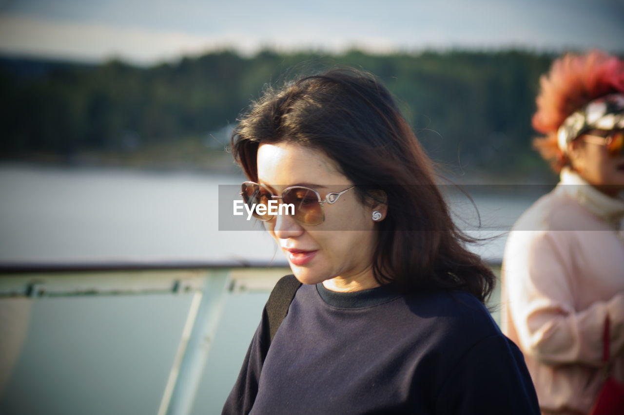 Woman in sunglasses against lake