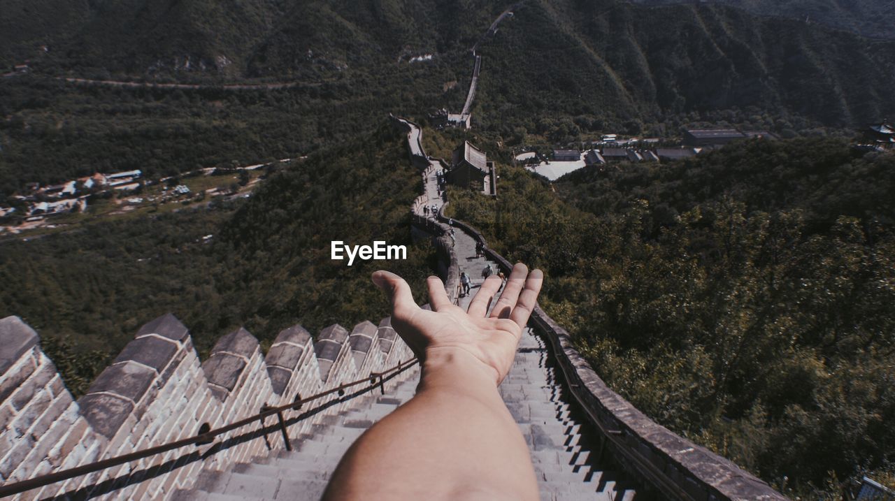Cropped hand of man against great wall of china