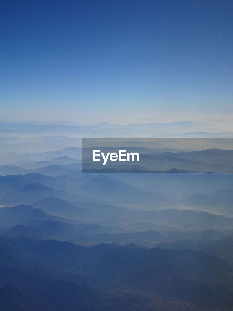 Scenic view of mountains against sky seen from airplane window