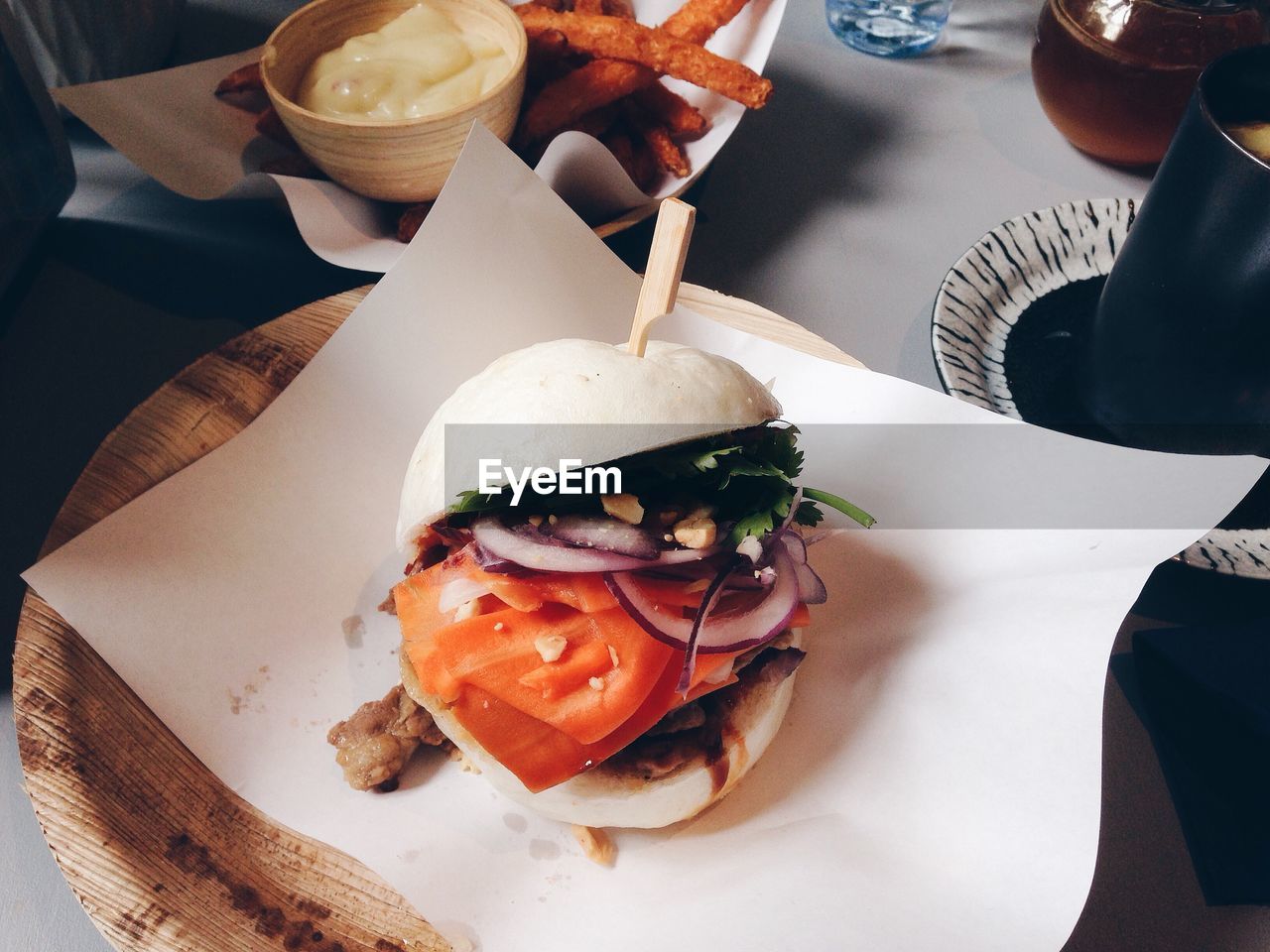 High angle view of burger served with fries and mayonnaise in plate on table indoors