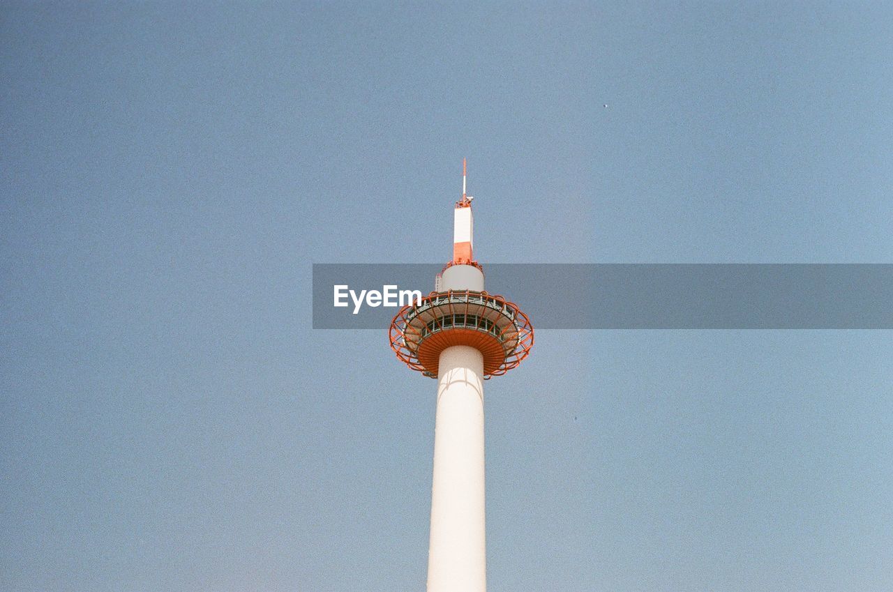 LOW ANGLE VIEW OF COMMUNICATIONS TOWER IN CITY AGAINST CLEAR SKY