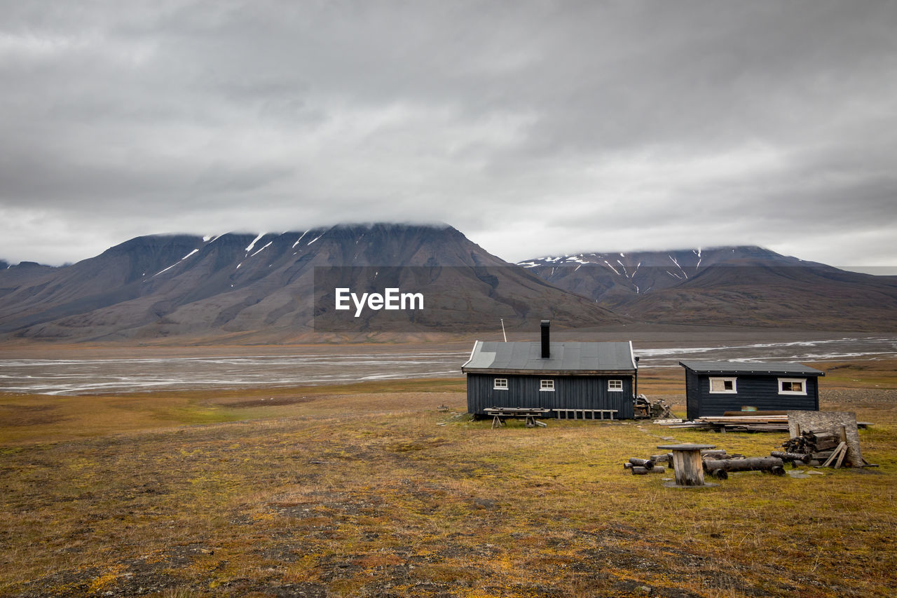 Typical wooden cottange in arctic landscape in svalbard, norway. scenic view of adventdalen