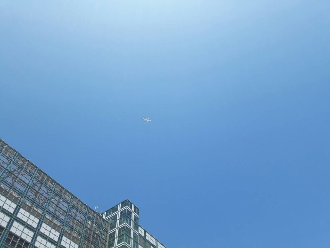 LOW ANGLE VIEW OF AIRPLANE AGAINST BLUE SKY