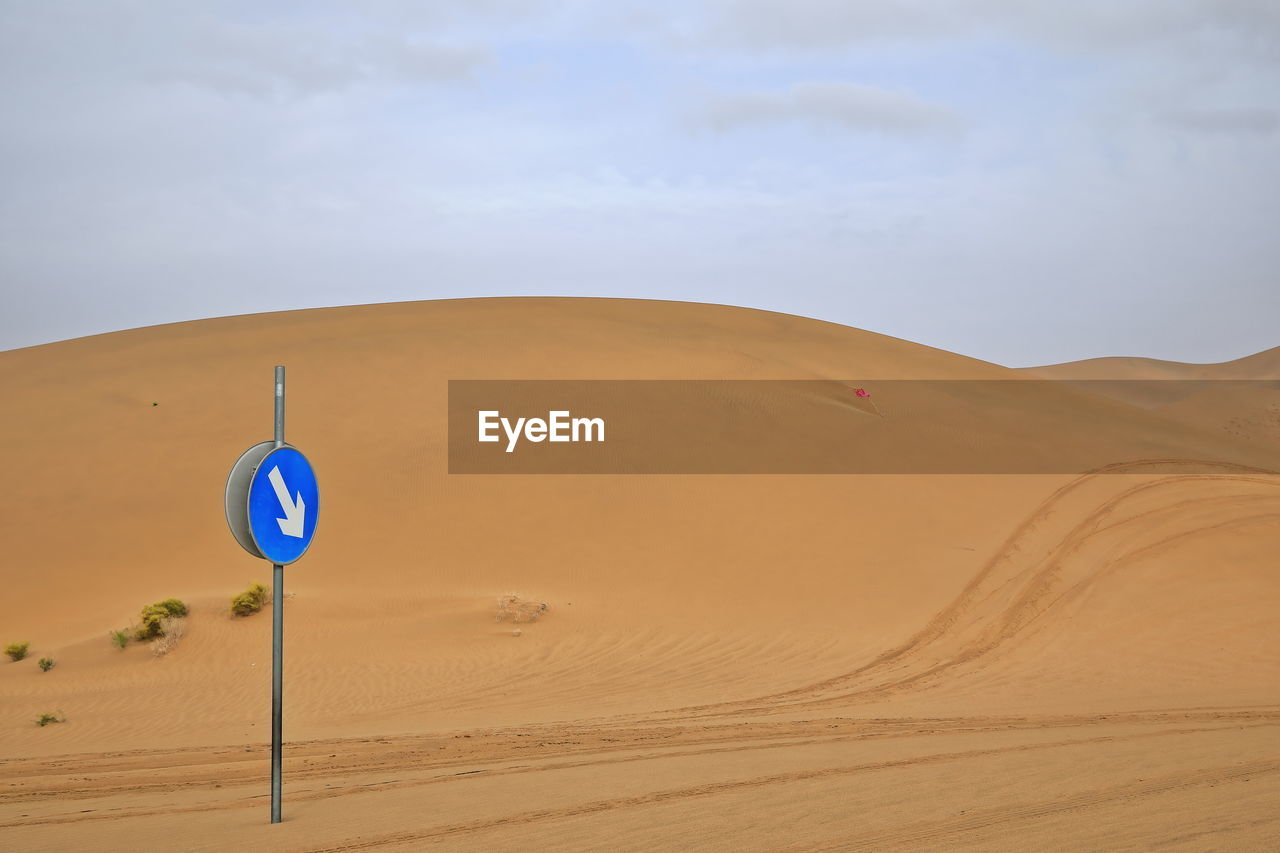 1026 traffic in the desert. mandatory direction sign among the dunes. badain jaran-nei mongol-china.