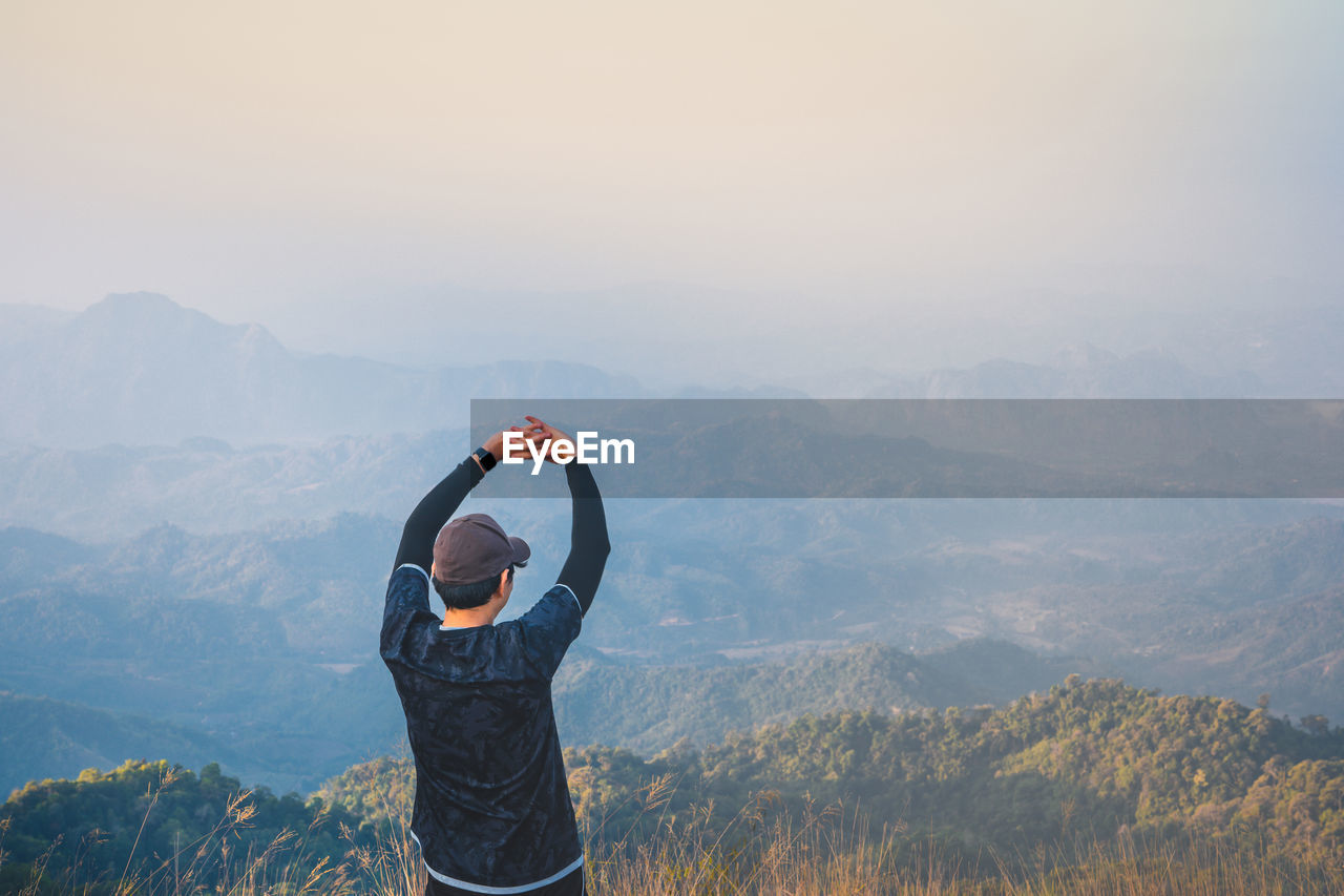 Wanderlust and relax in nature from hiker man camping with success and happiness on top of mountain