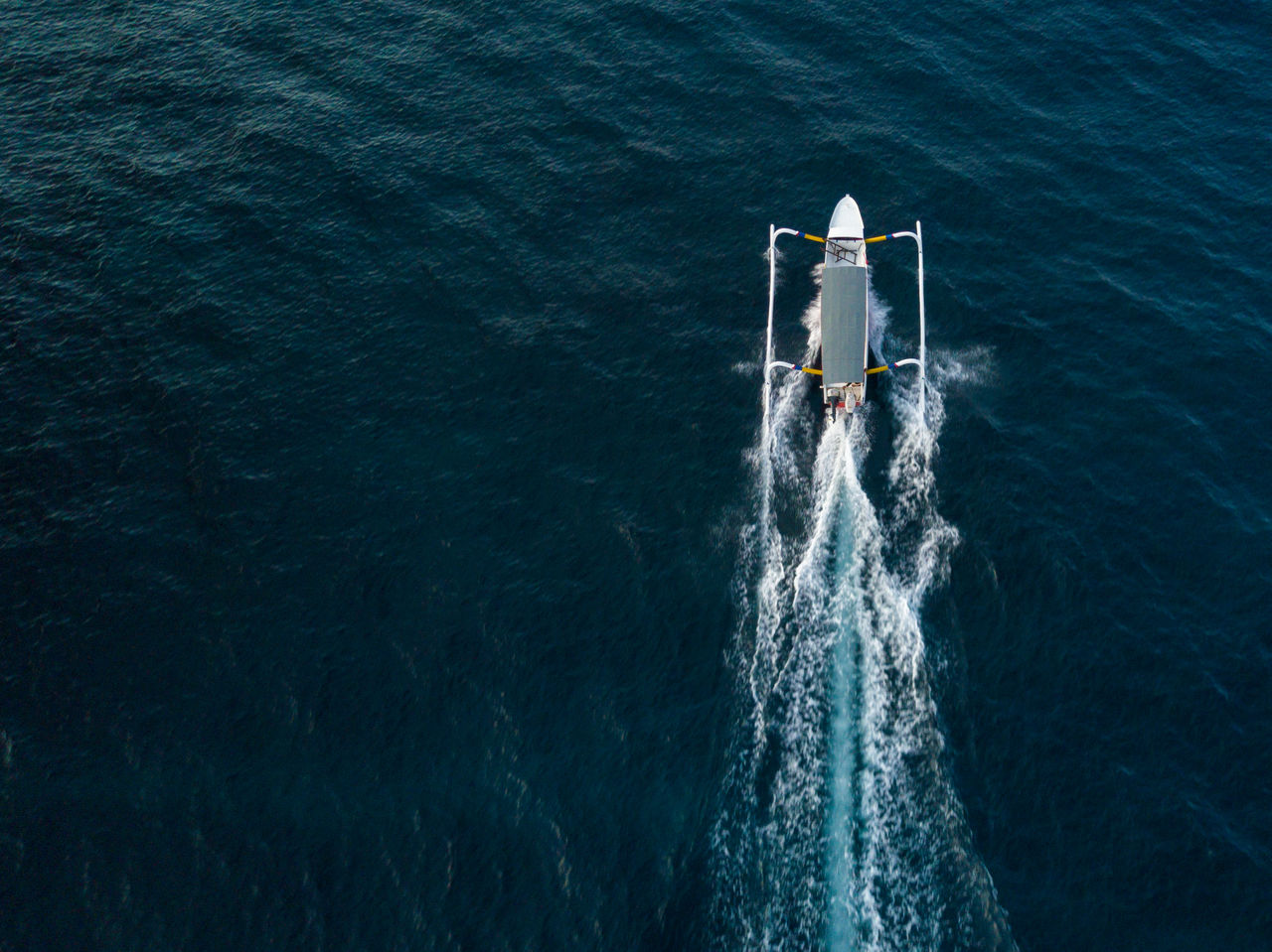 Aerial view of outrigger sailing on sea