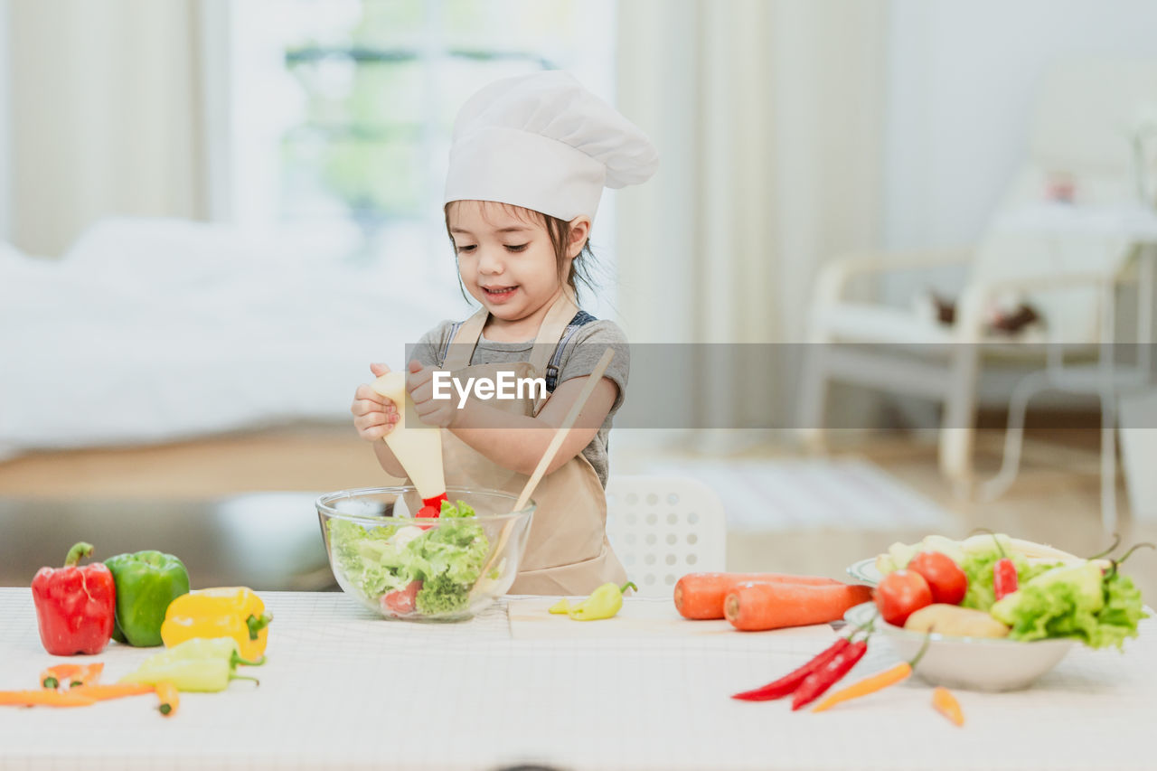 MIDSECTION OF WOMAN PREPARING FOOD
