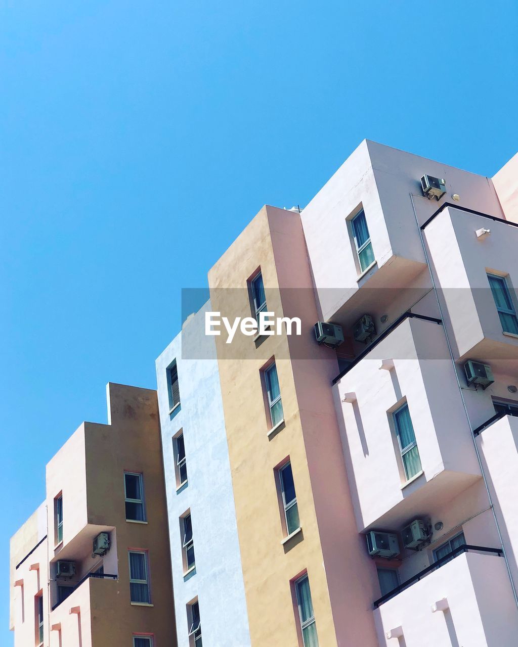 Low angle view of buildings against clear blue sky