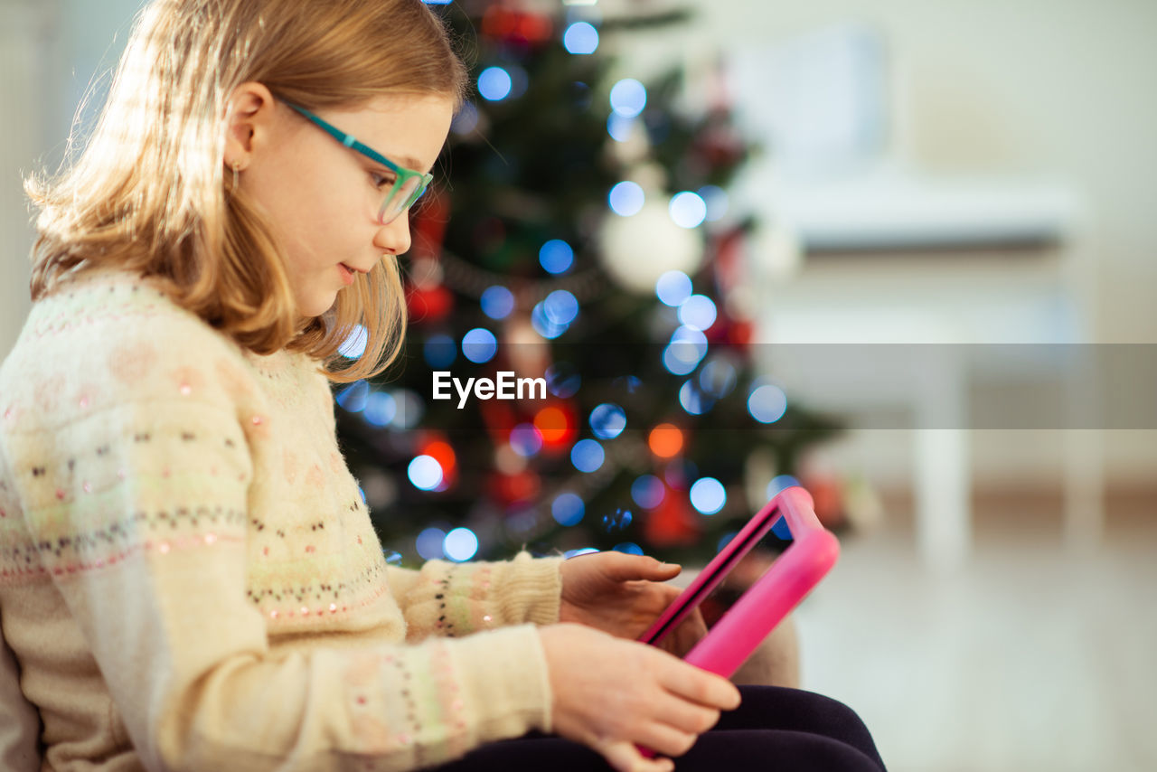 Girl using digital tablet at home during christmas
