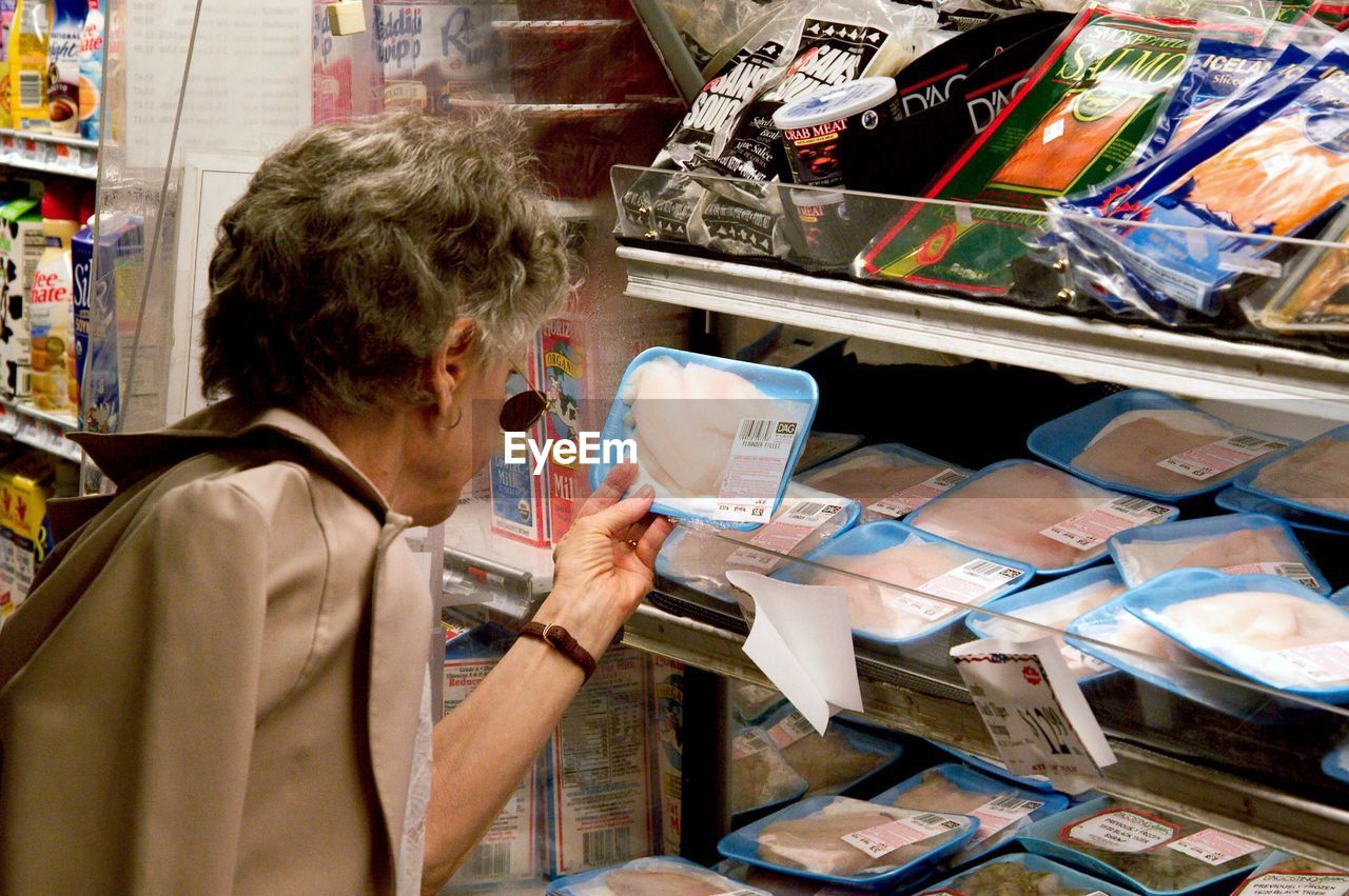 Woman looking at product at supermarket