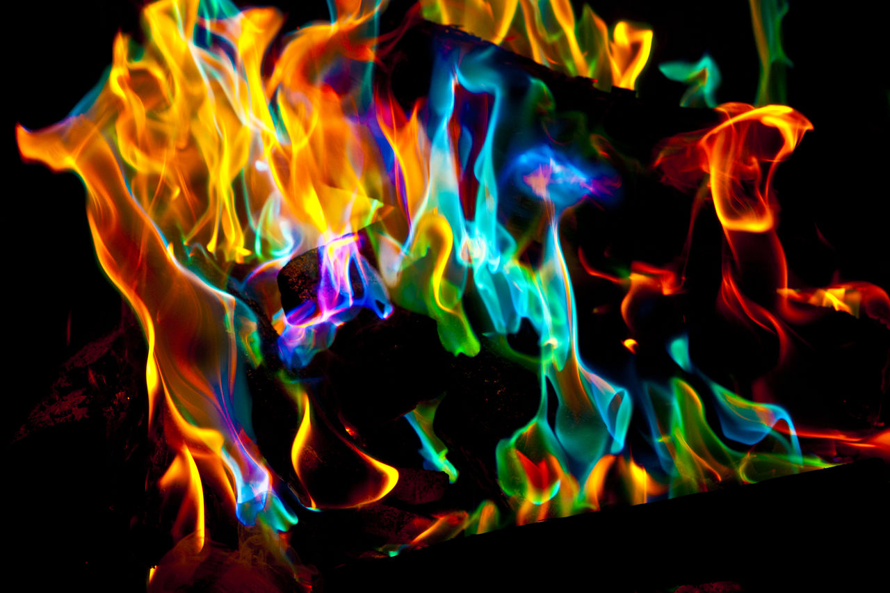 CLOSE-UP OF ILLUMINATED FIRE AGAINST BLACK BACKGROUND