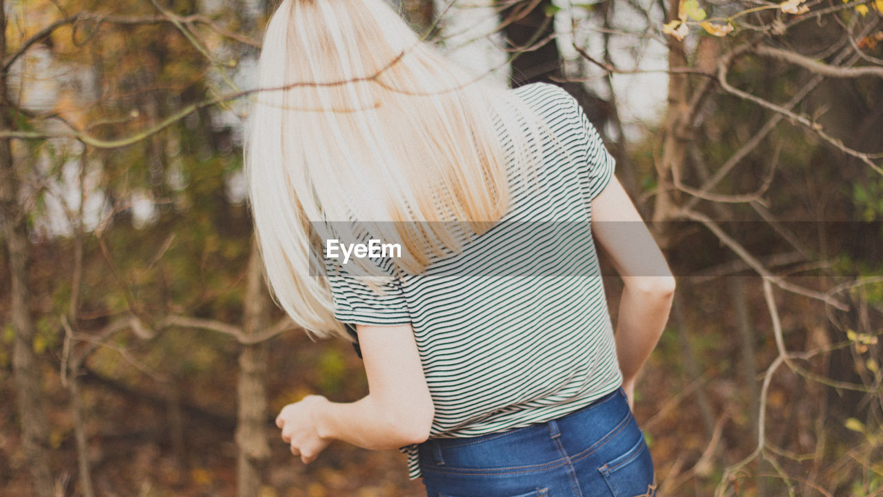 Low section of woman standing by tree