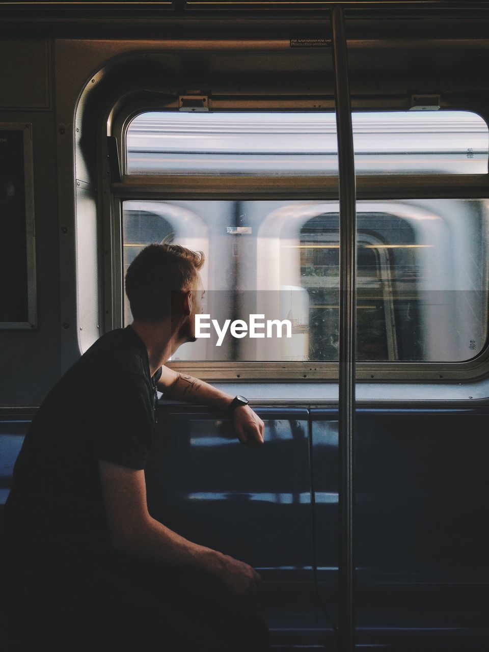 Man looking through window while traveling in train
