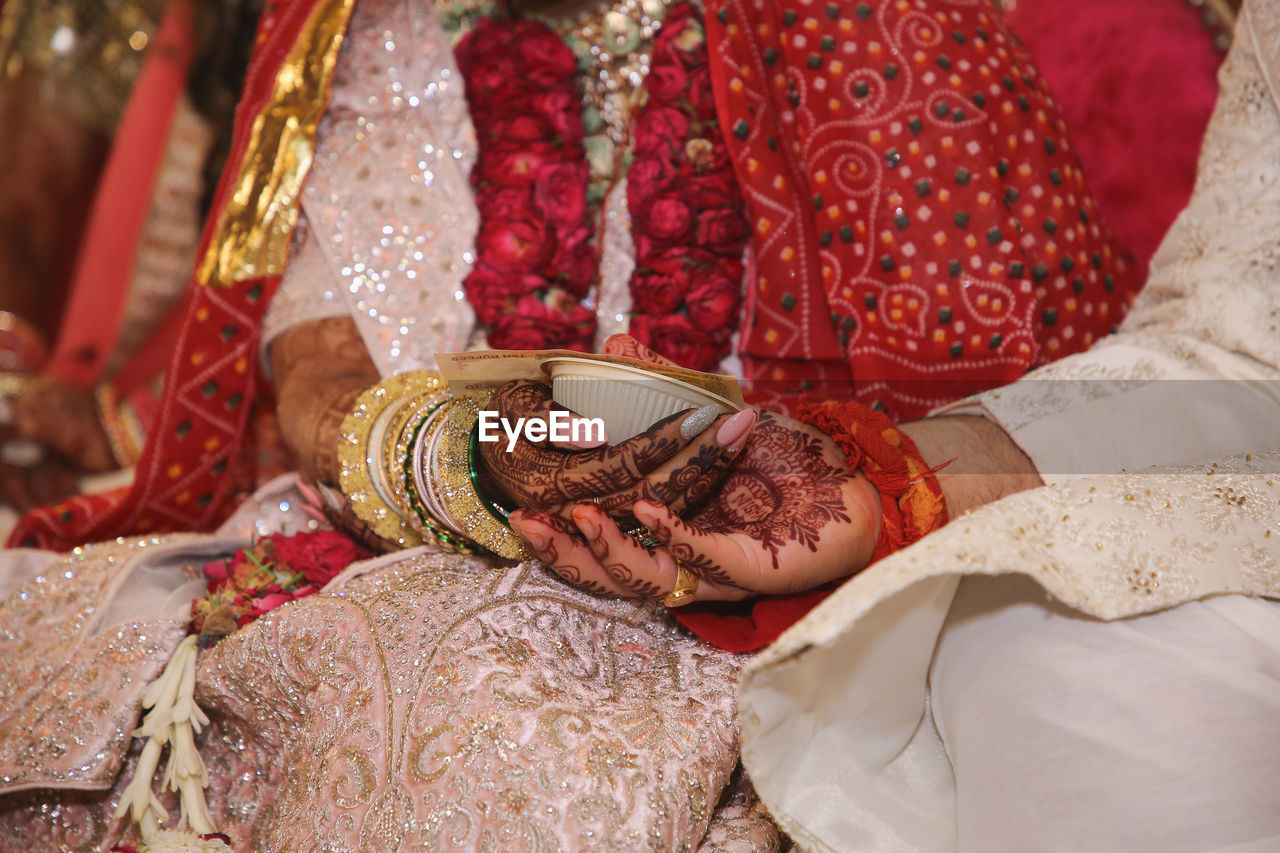 Bride and groom holding hands performing rituals of indian wedding