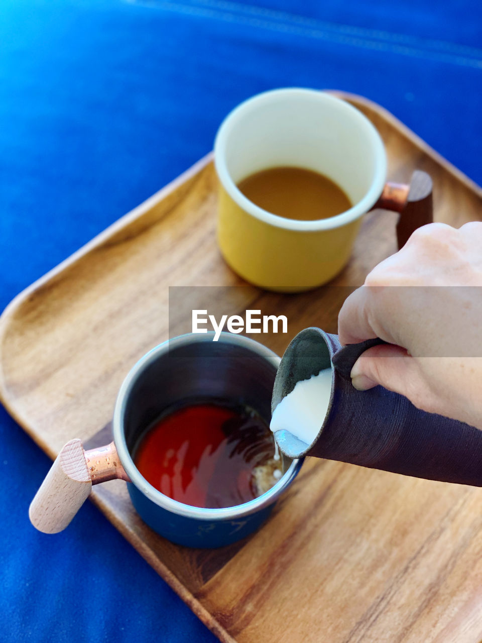 cropped hand of person holding coffee on table