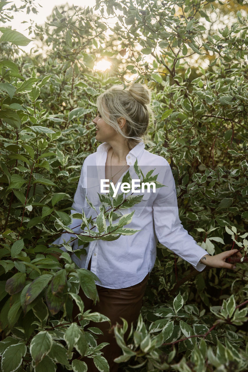 Woman standing by plants