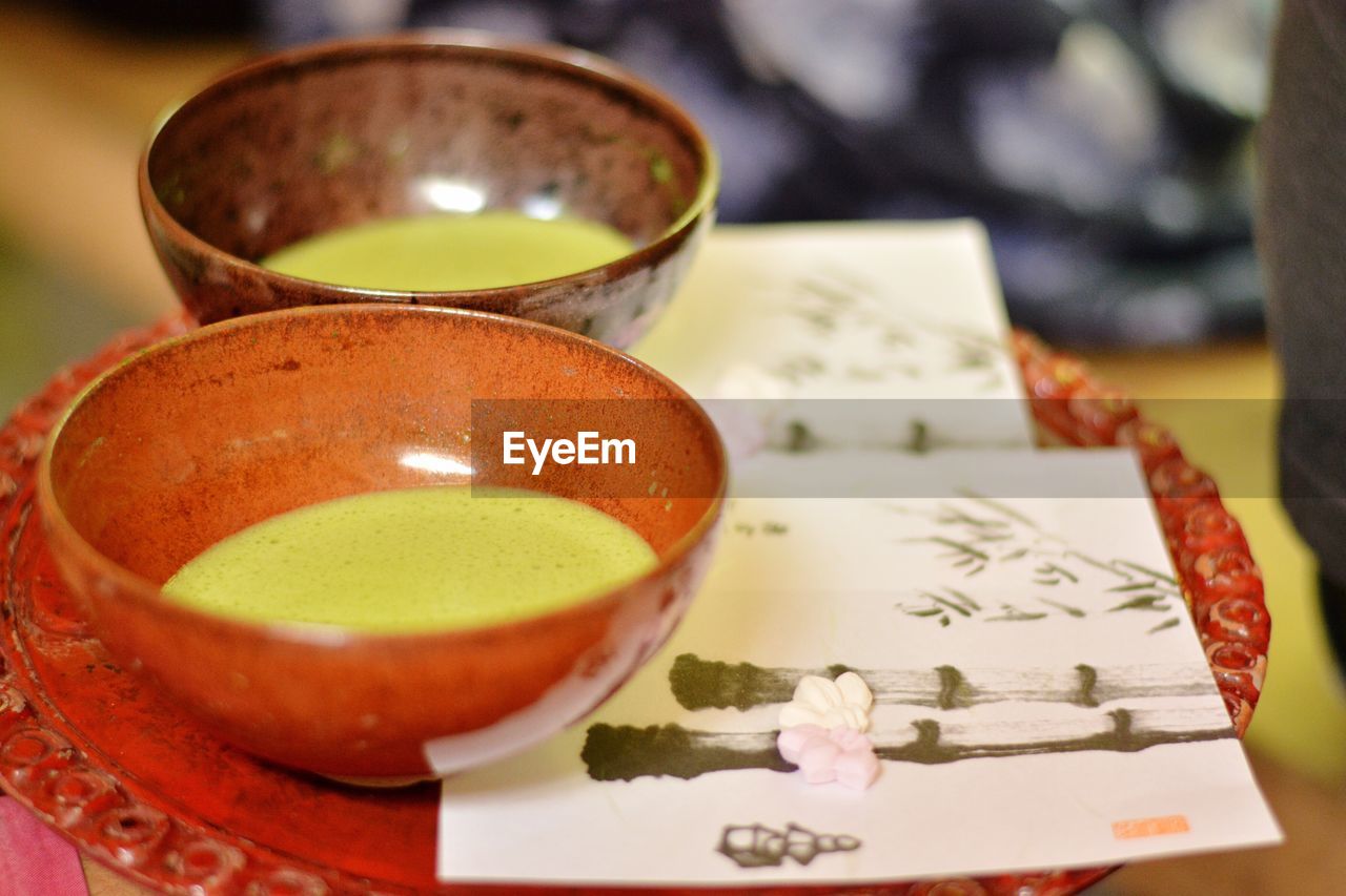 Close-up of japanese green tea in cup on plate