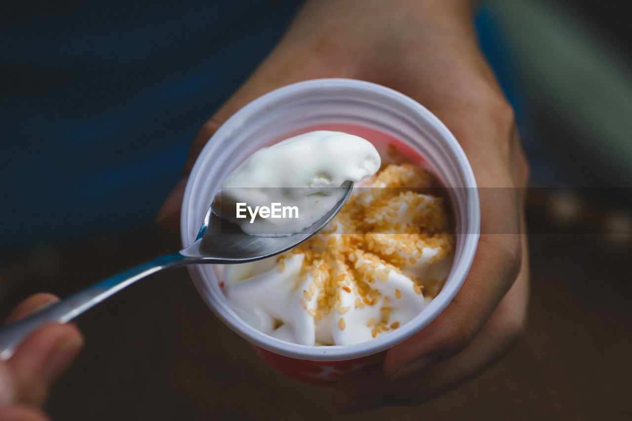 Cropped image of man holding ice cream in cup