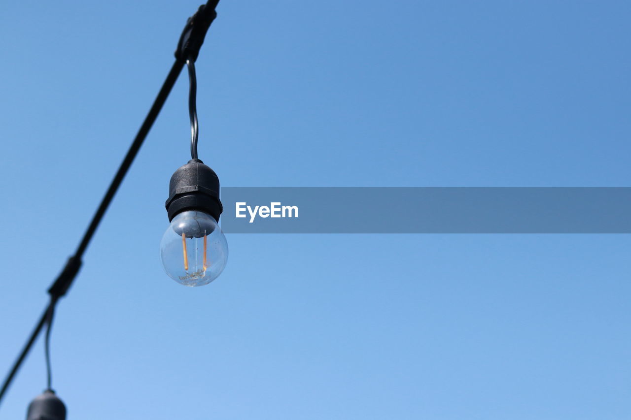 LOW ANGLE VIEW OF LIGHT BULB AGAINST CLEAR SKY