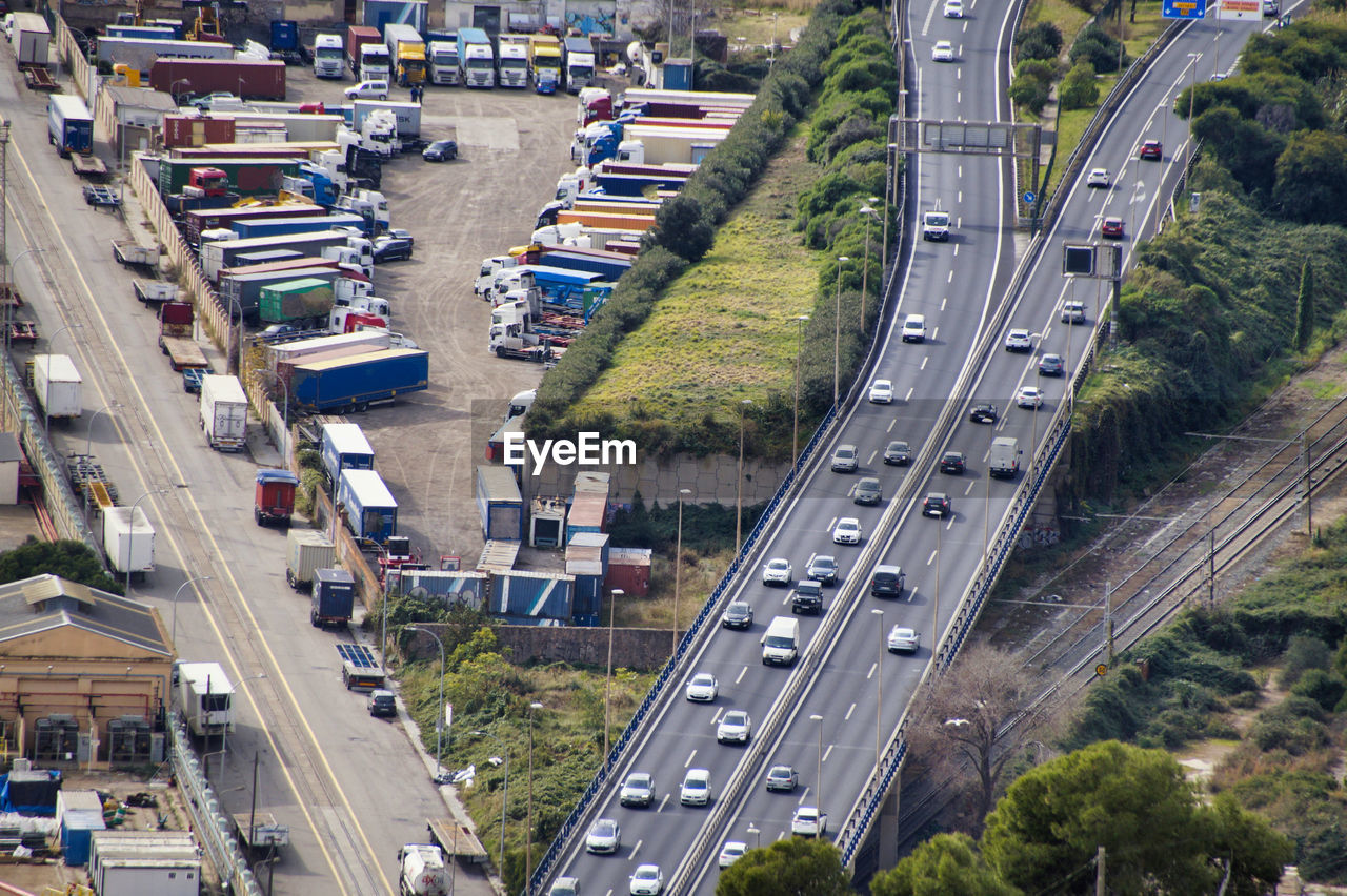 High angle view of traffic on city street and parked trucks with cargo container