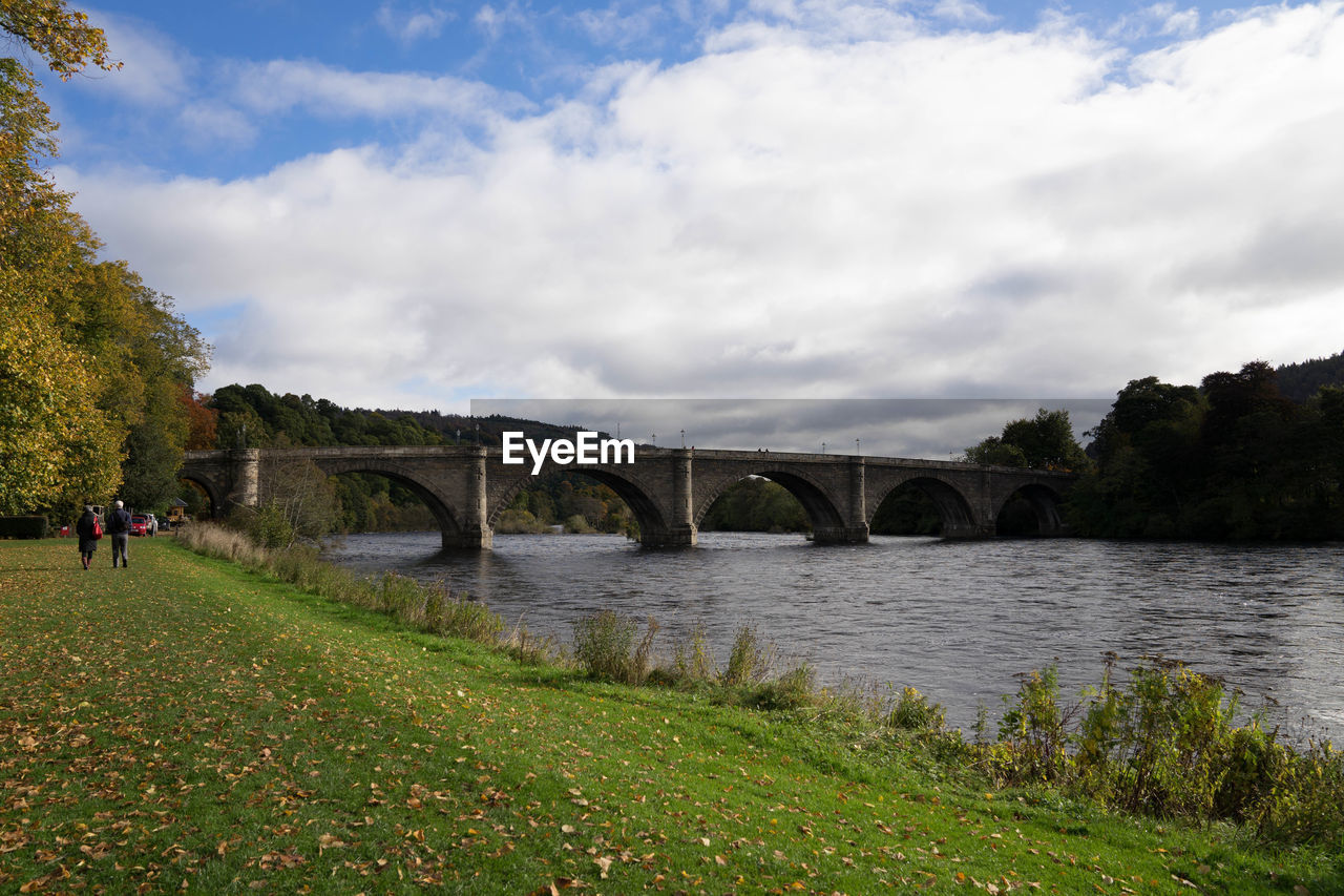 Arch bridge over river against sky