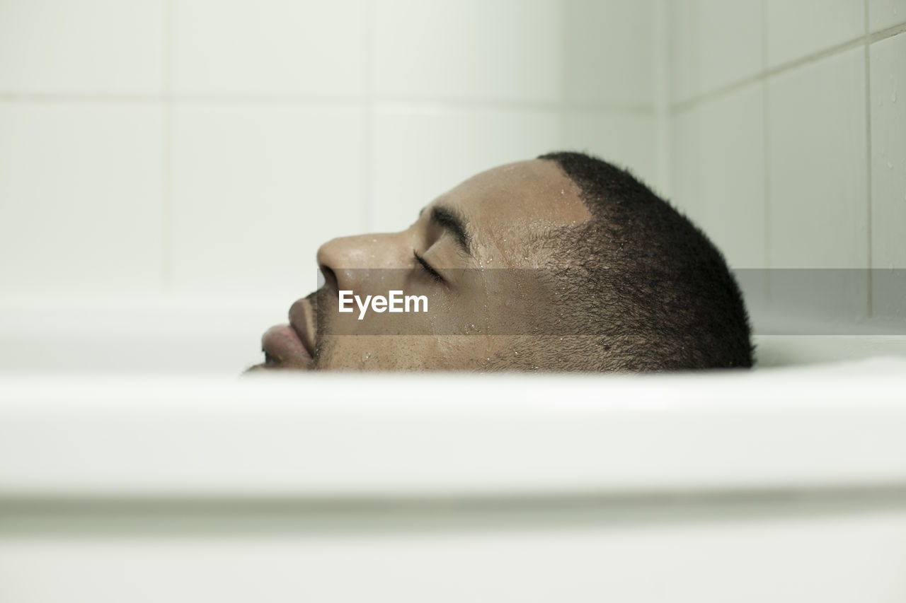 Close-up of man relaxing in bathtub