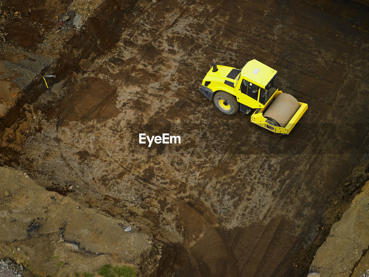 HIGH ANGLE VIEW OF YELLOW TOY CAR ON ROCK AT SHORE