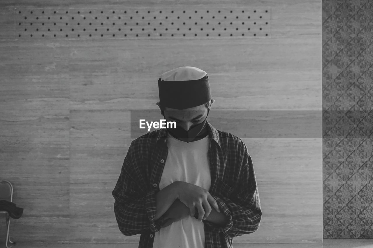 Muslim man praying shalat at mosque with mask during the covid-19 or corona virus pandemic