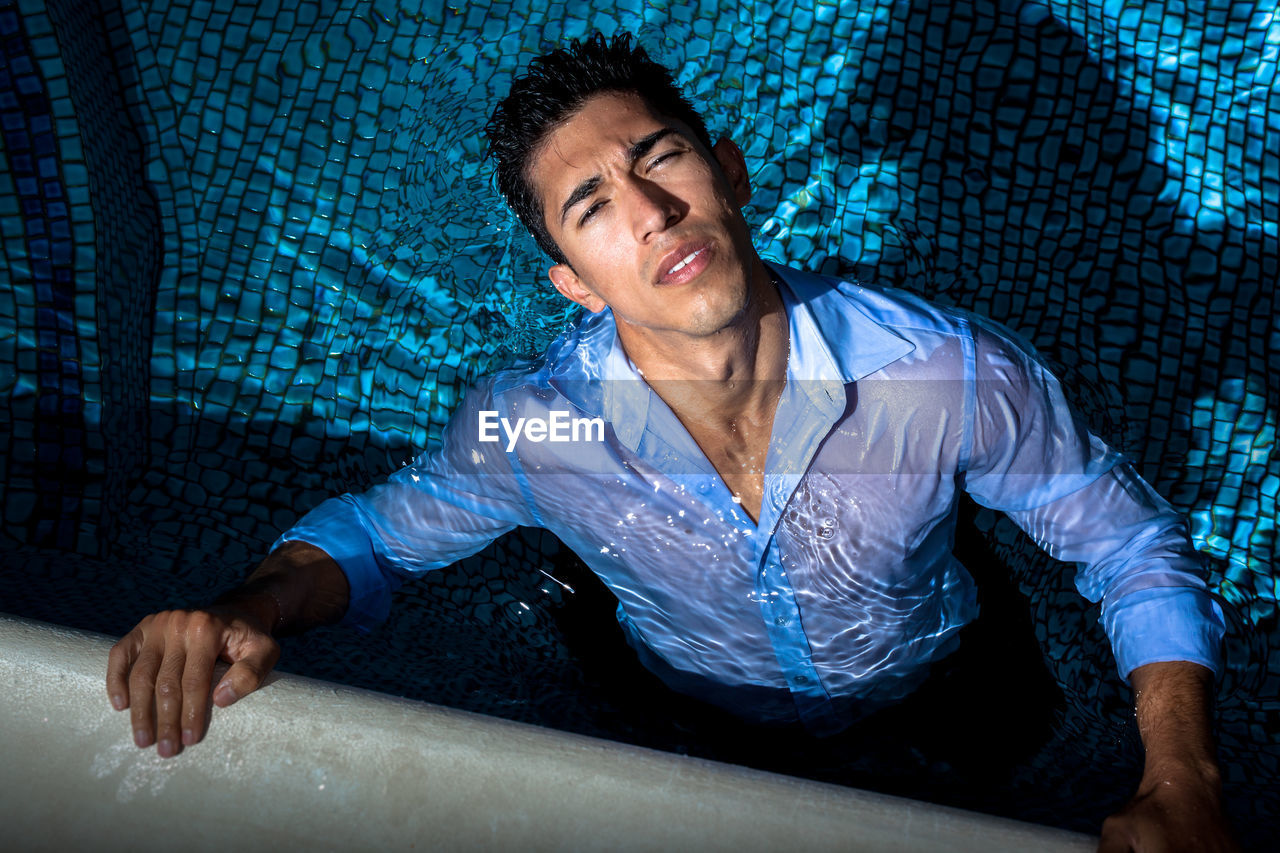 High angle portrait of young man swimming in pool