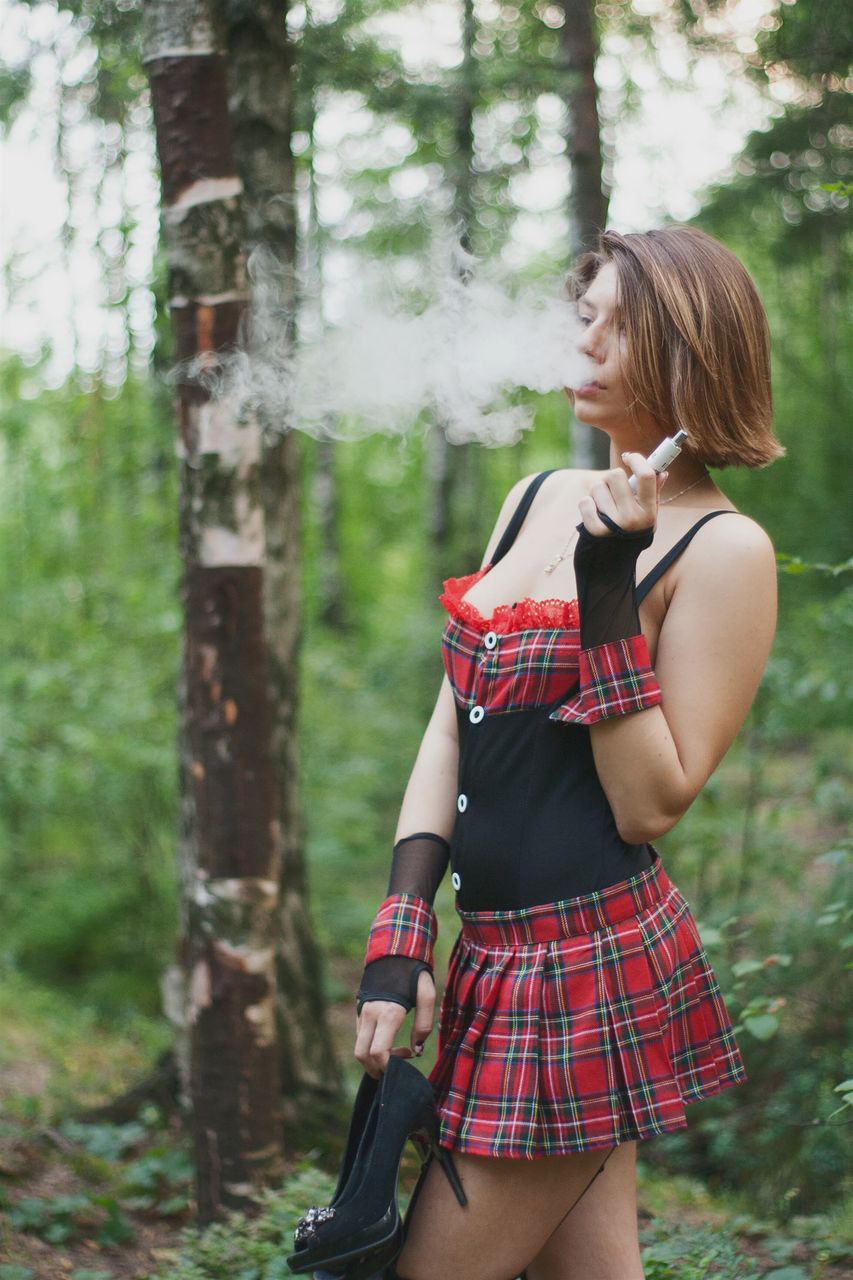 Beautiful Woman Smoking Electronic Cigarette While Holding 
