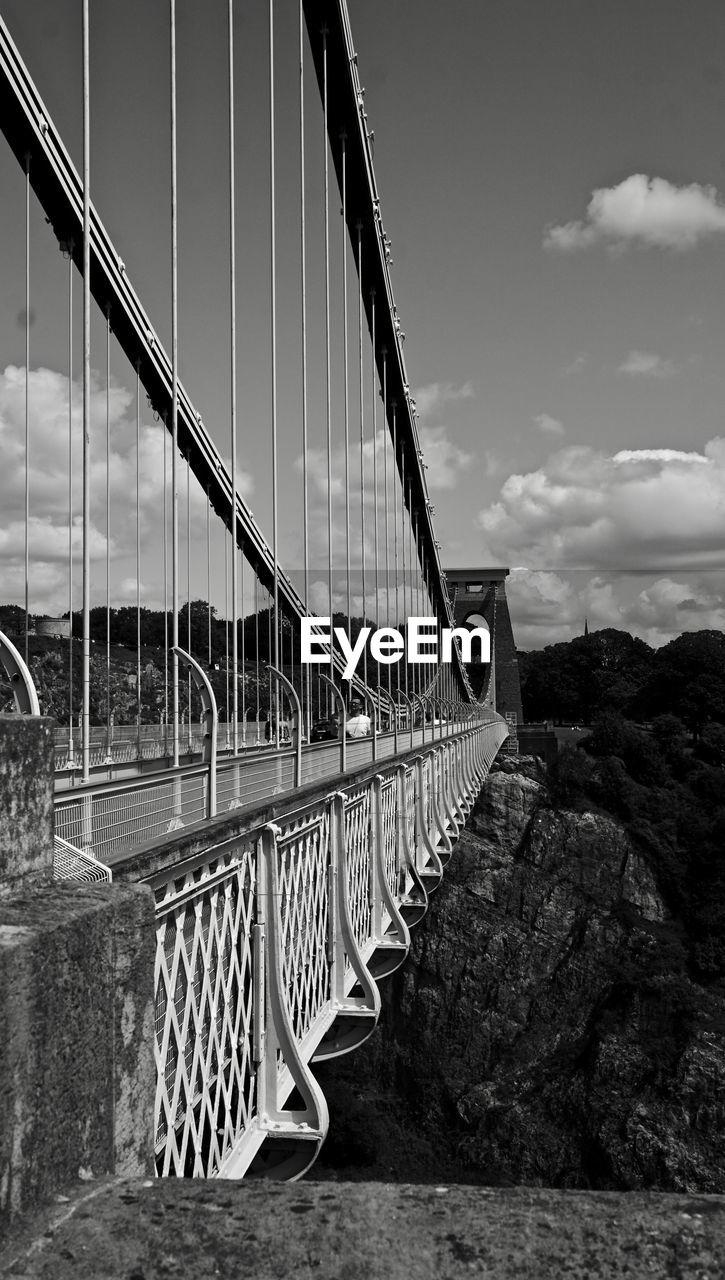 Bridge over river against cloudy sky