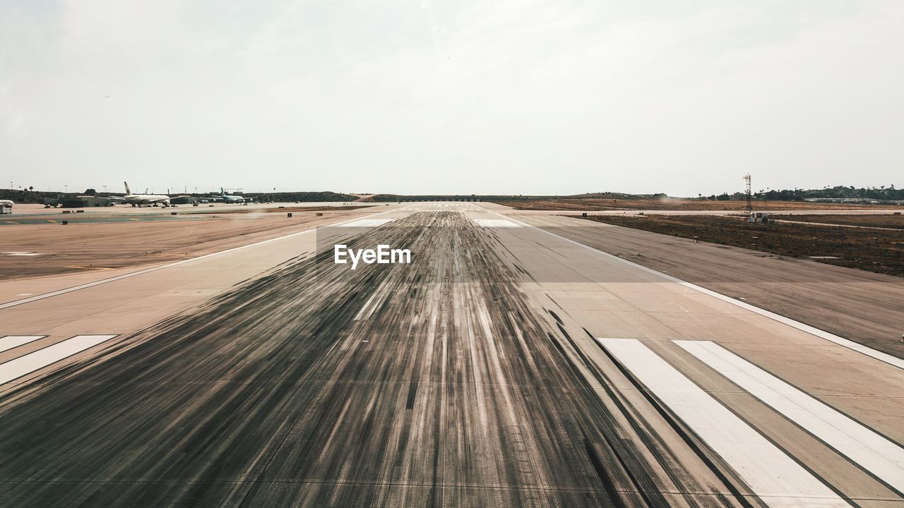 Empty airport runway against sky